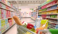 Supermarket trolley filled with vegetables in aisle